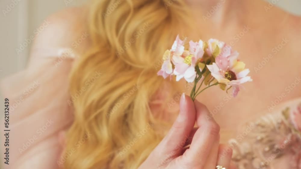 Close-up fingers hand holding small bouquet pink daisy flowers. Woman rotates, plays with plants. blonde girl healthy long hair. Inhales smell aroma. part of body. video 4k. freedom from allergies Close-up fingers hand holding small bouquet pink daisy flowers. Woman rotates, plays with plants. blonde girl healthy long hair. Inhales smell aroma. part of body. video 4k. freedom from allergies