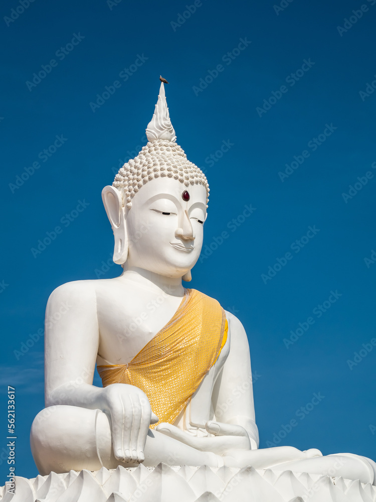 A white Buddha image with a clear blue sky as a backdrop A white Buddha image with a clear blue sky as a backdrop