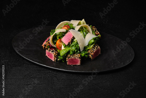 Tuna salad with parmesan on black plate