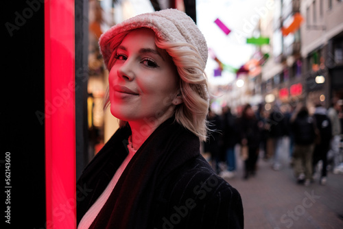 Portrait of young woman illuminated by red neon light.