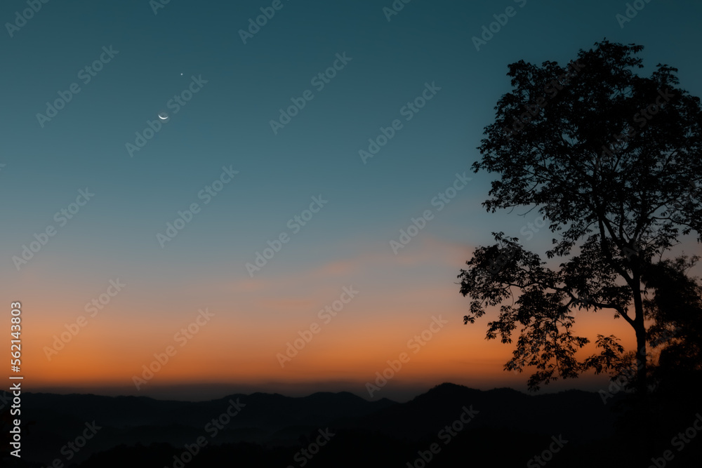 View of moon and star in blue hour before sunrise