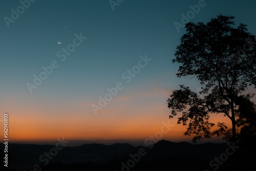 View of moon and star in blue hour before sunrise