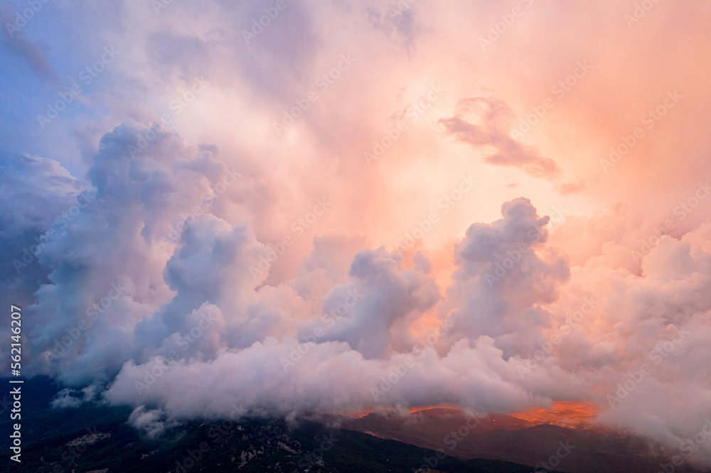 Panoramic view of the mountains in incredible clouds shot in the beautiful sunset light. Drone shot top view.