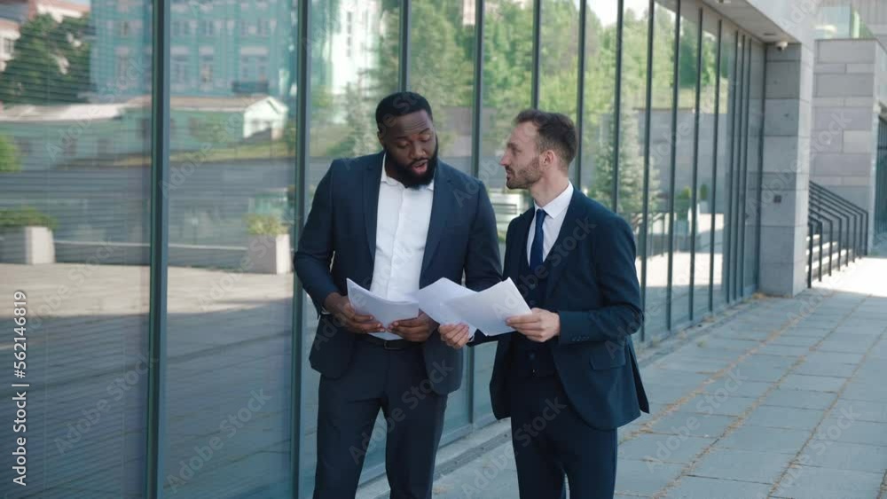 Two surprised diverse men entrepreneur in formal suits having successful deal celebrating victory. African american and caucasian men entrepreneur winners making Yes gesture near office building. Two surprised diverse men entrepreneur in formal suits having successful deal celebrating victory. African american and caucasian men entrepreneur winners making Yes gesture near office building.