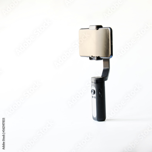 Modern smartphone and selfie stick - a three-axis stabilizer for photo and video shooting on mobile phone. Gadgets for blogging, streaming and video conferencing. Copy space. Selective focus.
