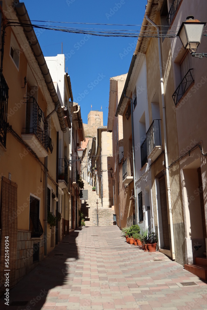 Biar, Alicante, Spain, January 14, 2023: Narrow street with the castle in the background in Biar, Alicante, Spain