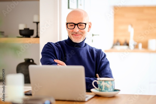 Wallpaper Mural Middle aged businessman wearing casual clothes and using laptop while working from home Torontodigital.ca