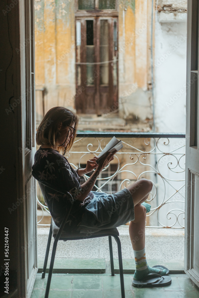 Focused woman reading book on balcony Focused woman reading book on balcony