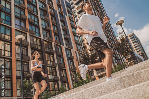 Εκτύπωση καμβά Athletic guy and a fit girl running together outdoors