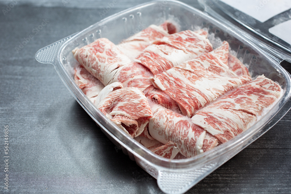 A view of beef boneless short rib in a plastic container.