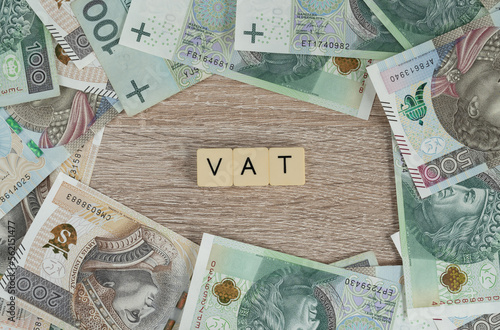 VAT is value added tax. Flat lay with Polish złoty money, PLN zloty banknotes. Rising economics inflation in Poland concept. Government anti-inflation shield tax cut, reduced VAT on some products.