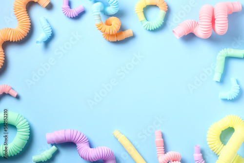 Pop tubes toys, developing fine motor skills and hand-eye coordination on pastel blue background. Perfect for early childhood education and occupational therapy.