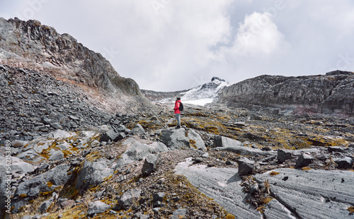 Hiker standing on rock admiring rocky hills photo