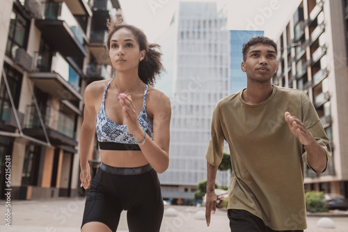 Fit girl and a sporty guy running forward