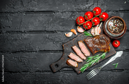 Grilled beef steak with rosemary and tomatoes.