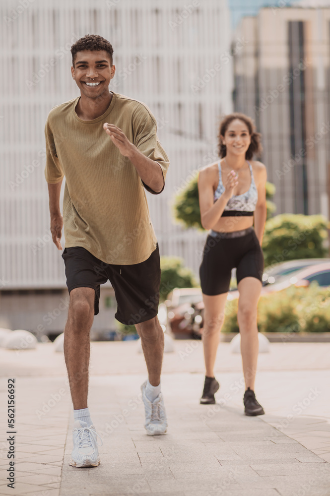 Sporty young man and a girl performing an aerobic exercise