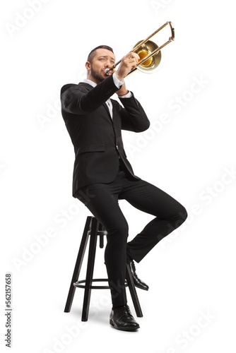 Photography Male musician sitting on a chair and playing a trombone