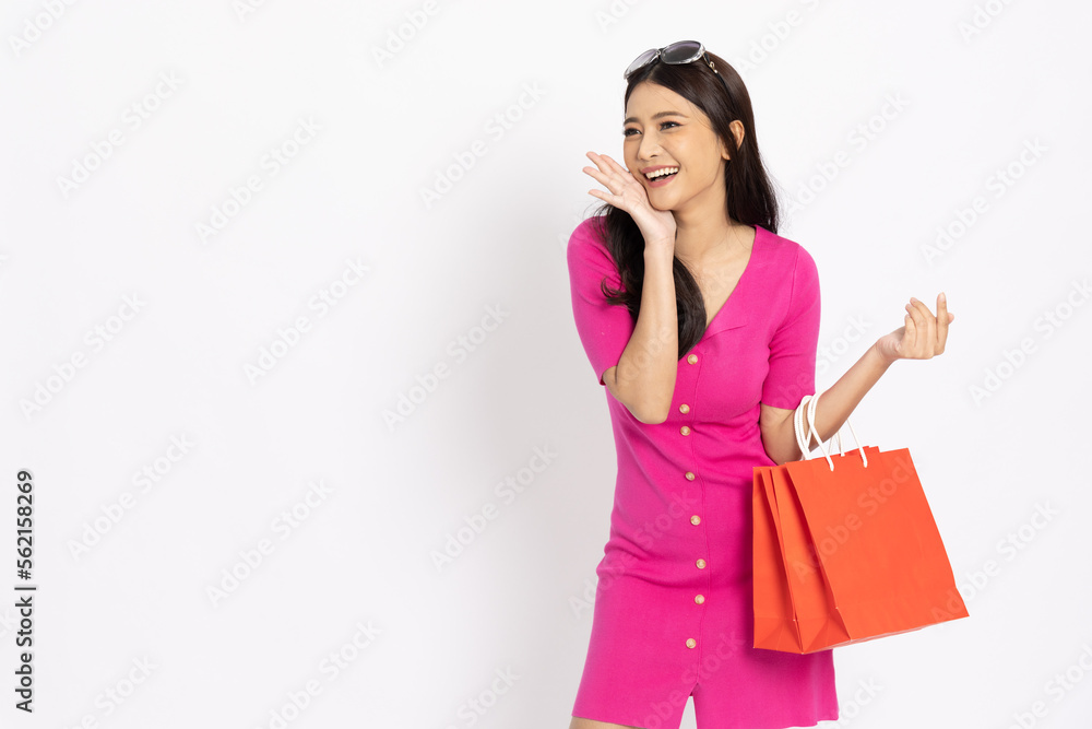 Portrait of Asian woman holding red shopping bags isolated on white background, Shopper or shopaholic concept Portrait of Asian woman holding red shopping bags isolated on white background, Shopper or shopaholic concept