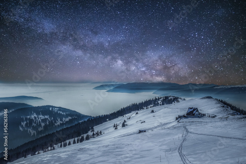 Magical Night at Snowy Chasseral Peak: Milkyway, Stars and a Mountain cabin in a foggy Landscape