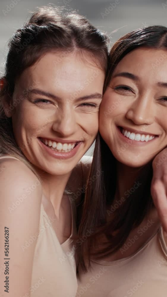 Vertical video: Cheerful beauty models posing on camera for campaign, advertising self acceptance and skincare products. Happy friends with different skintones promoting diversity and body confidence. Vertical video: Cheerful beauty models posing on camera for campaign, advertising self acceptance and skincare products. Happy friends with different skintones promoting diversity and body confidence.
