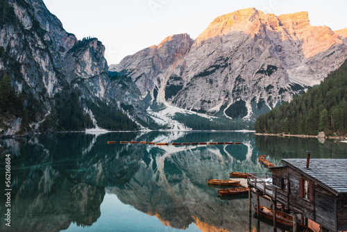 Stunning view of the Lake Braies (Lago di Braies) with some wooden boats and beautiful mountains reflected in the water. Lago di Braies is an alpine lake in the Dolomites, Italy.