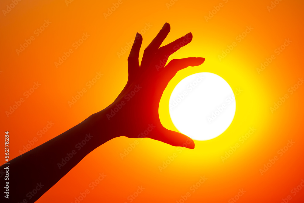 silhouette of a hand against the background of the evening sun silhouette of a hand against the background of the evening sun