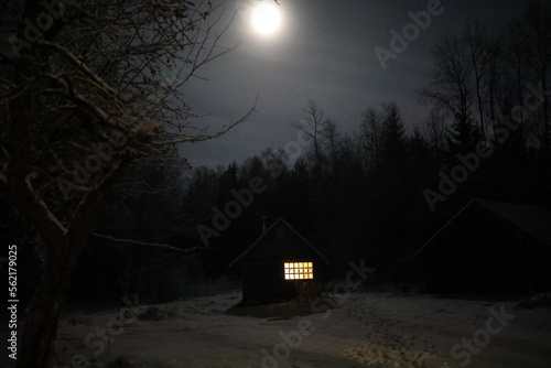 Landscape with house at night under dark sky with full moon. Spooky landscape with house in night.