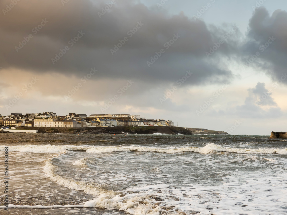 View on Kilkee beach and town houses in the background. County Clare, Ireland. Nobody. Popular summer resort. Atlantic ocean, Irish seascape. Cloudy sky.