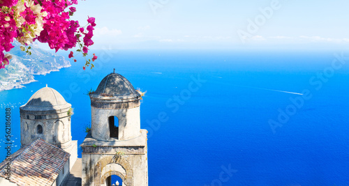 Two belltowers with flowers and sea in Ravello village, Amalfi coast of Italy, web banner format photo