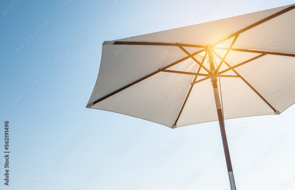 Luxury umbrella in the sun against blue sky. Hot summer relaxation and vacation concept. - obrazy, fototapety, plakaty 