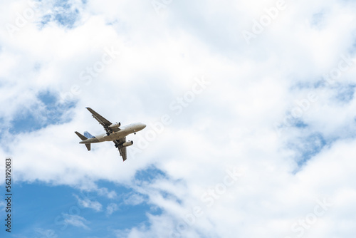 landing plane on blue sky with clouds