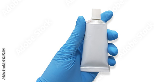 Gloved hand holding a tube of ointment on white background