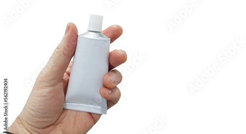 Hand holding a tube of ointment on white background