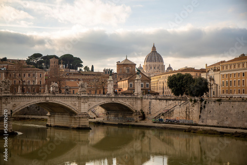 Bridge over the Tiber river in Rome with a view in the distance of Saint Peter's Basilica