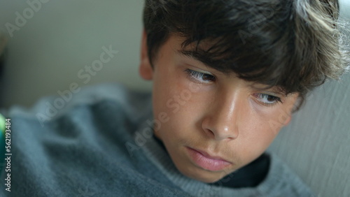 Pensive thoughtful young boy face close-up