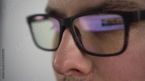 Wallpaper Mural Young man surfs the internet. Reflection of a pc monitor in glasses. The IT specialist looks at the monitor attentively. Glasses close-up. Torontodigital.ca