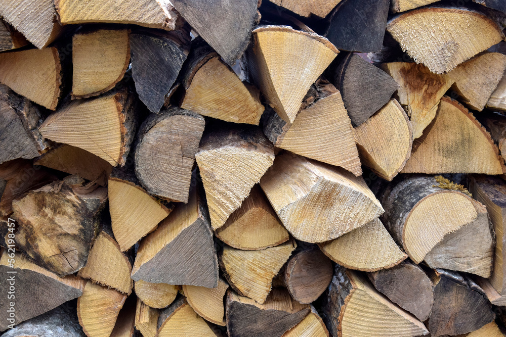 Fototapeta premium Chopped firewood is stacked in neat piles. Woodpile. Background. Close-up. Selective focus.