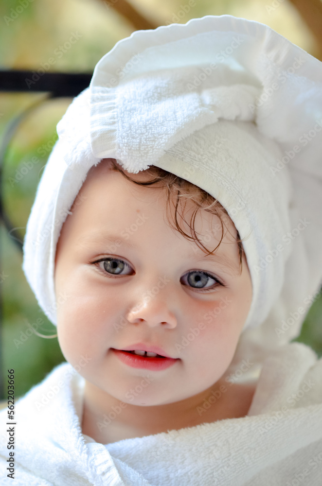 Cute portrait of a young girl getting out of the bath and waiting in the garden Cute portrait of a young girl getting out of the bath and waiting in the garden