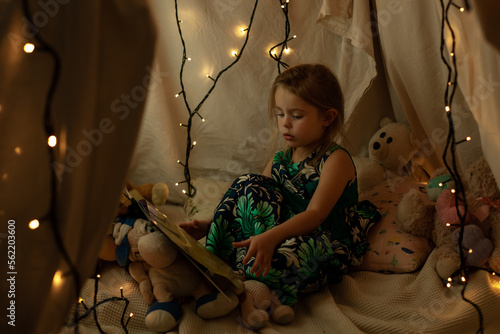 the girl is playing and reading a book in the hut