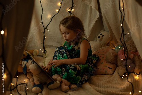 the girl is playing and reading a book in the hut