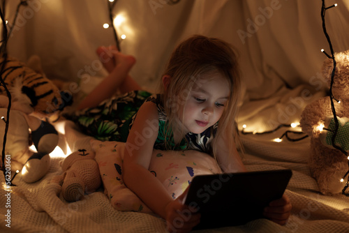 the girl is looking at the tablet