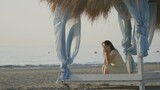 melancholic woman sit on canopy, waving sea