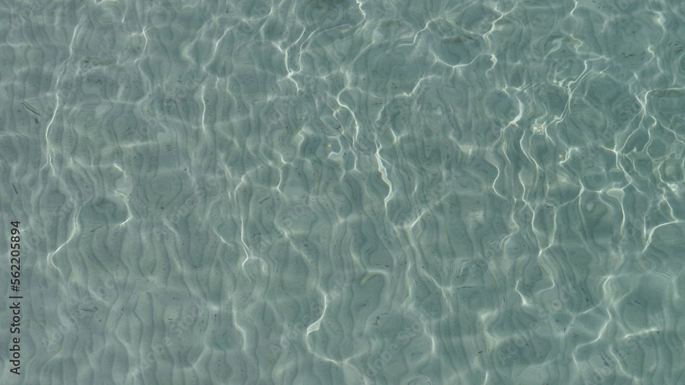Detail of shallow clear sea water ripples on white fine sand