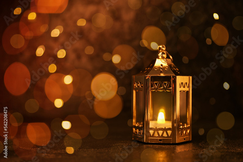 Photography Muslim lantern with glowing candle on dark background with space for text