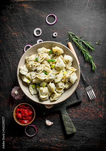 Dumplings with garlic, onion rings and tomato paste.