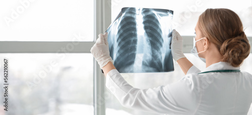 Photographie Female doctor with x-ray image of lungs in clinic