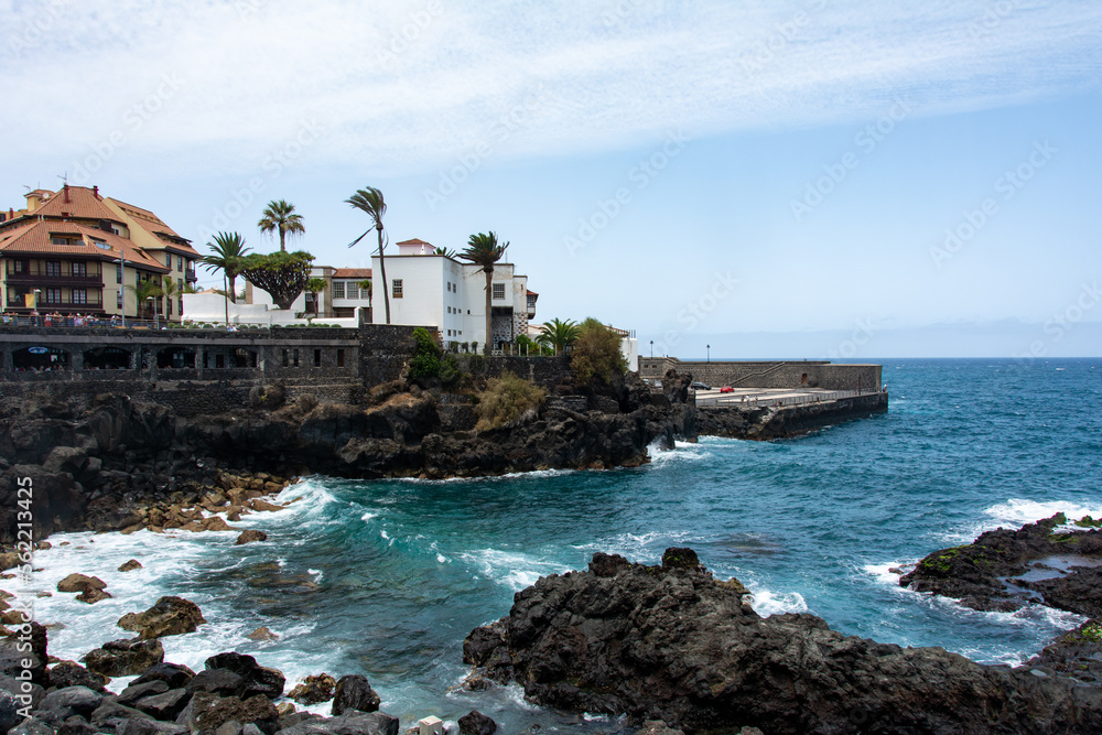 Fototapeta premium View of the coast and town of Puerto de la Cruz, Tenerife, Spain, with lava stones in the sea