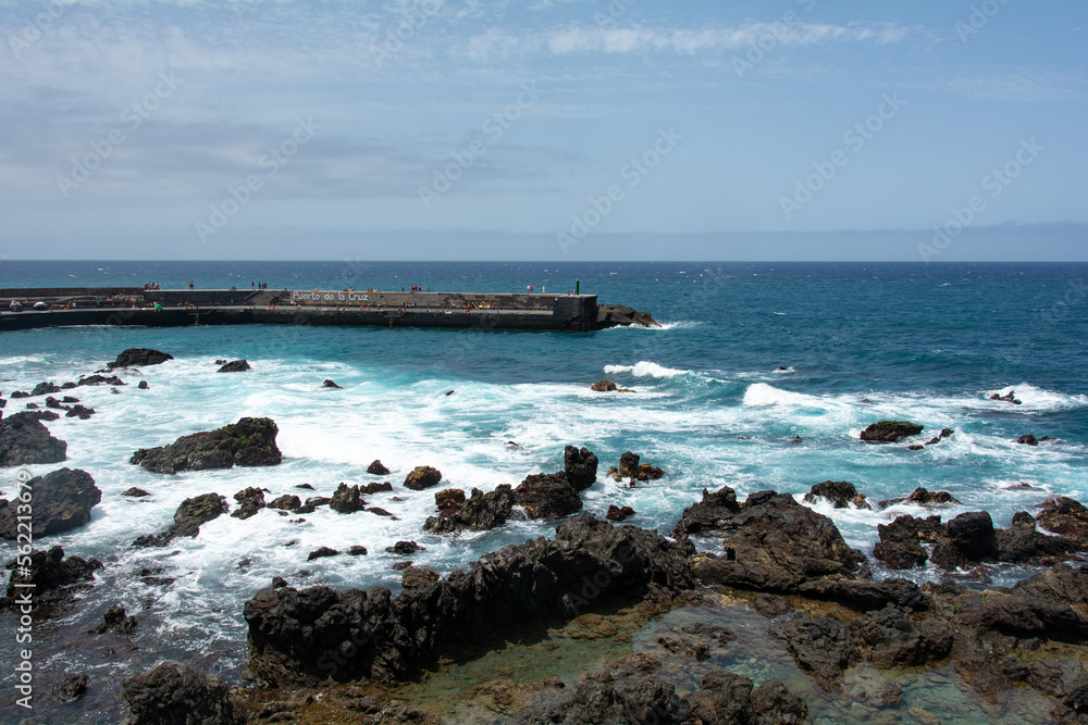 Bay in the city of Puerto de la Cruz with lava stones in the sea