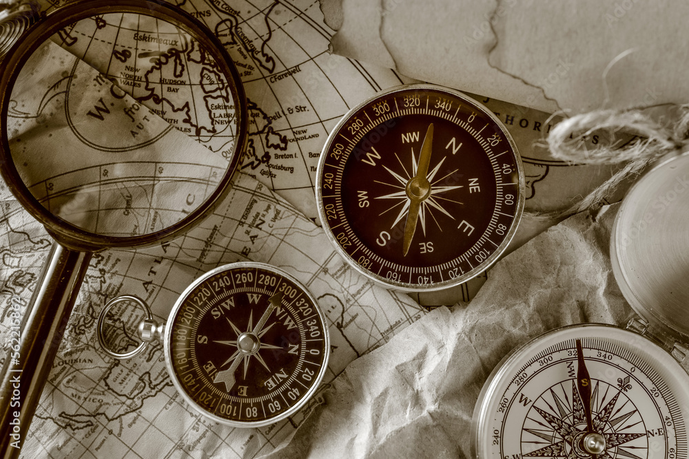 Different compasses and magnifier on world map