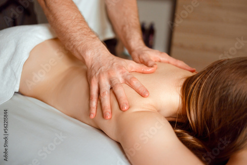 Cropped image of male masseur massaging woman at spa